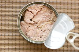 Tinned Tuna Fish. Ready for eat without cooking On a bamboo straw kitchen utensil surface.
