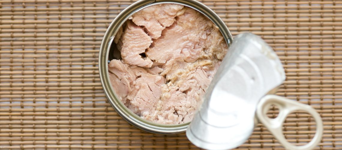 Tinned Tuna Fish. Ready for eat without cooking On a bamboo straw kitchen utensil surface.
