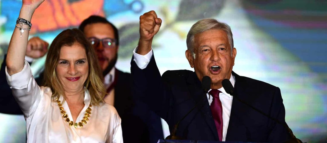 Newly elected Mexico's President Andres Manuel Lopez Obrador (R), running for "Juntos haremos historia" party, next to his wife Beatriz Gutierrez Muller, cheers his supporters at a hotel after winning general elections, in Mexico City, on July 1, 2018. (Photo by PEDRO PARDO / AFP)        (Photo credit should read PEDRO PARDO/AFP/Getty Images)