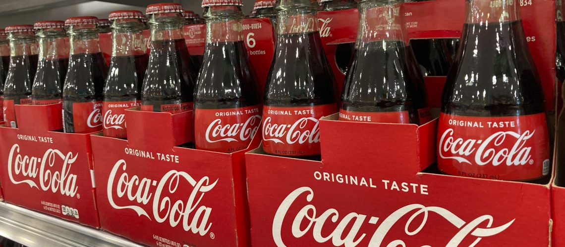 Bottles of Coca-Cola are stacked on a shelf in a grocery store, Wednesday, Dec. 15, 2021, in Surfside, Fla.   Coca-Cola’s revenue rose 10% to $9.5 billion in the fourth quarter, Thursday, Feb. 10, 2022, as coffee shops, movie theaters and other venues continued to reopen. The Atlanta-based beverage giant said the fourth quarter was the first time since the pandemic that away-from-home sales volumes were ahead of 2019 levels.(AP Photo/Wilfredo Lee)