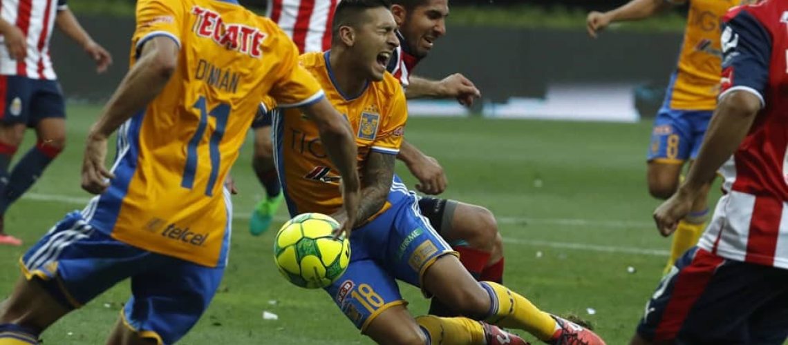 Tigres' Victor Sosa, center, is taken down in the penalty area in a controversial play in the final minutes of the Mexican soccer league final match against Chivas, in Guadalajara, Mexico, Sunday, May 28, 2017. Chivas won the match and the championship 2-1.(AP Photo/Eduardo Verdugo)