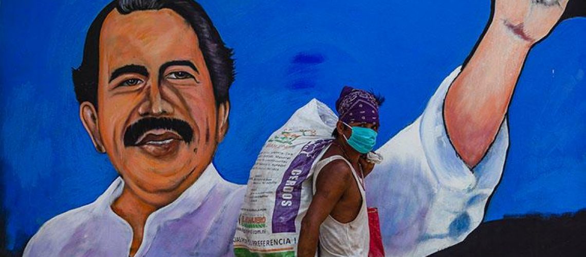 A homeless man wears a face mask against the spread of the new coronavirus, COVID-19, as he walks past a mural depicting Nicaraguan President Daniel Ortega, in Managua on April 9, 2020. - More than 1.46 million cases have been officially recorded and at least 86,289 people have died in 192 countries since the virus emerged in China in December, according to an AFP tally at 1900 GMT Wednesday based on official sources. (Photo by INTI OCON / AFP)
